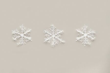 White snowflakes on gray background. Winter holidays concept.
