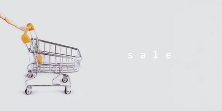 Banner with shopping cart and hand. Grocery shopping and sale concept. Black friday, online shopping and store concept. Sale discount. Background with copyspace. Creative design. Stock photography.の写真素材