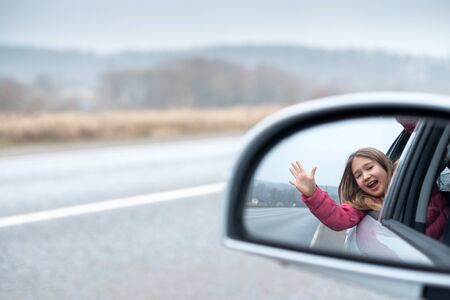 Young girl ride car and look out open window. Trip and responsible travel concept Teenager lifestyle. Childhood memories. Family time and road trip. Stock photo.の写真素材