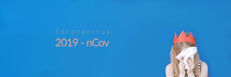 Coronavirus 2019 n-Cov concept with text. Girl with red crown and white handkerchief. Sars virus. Blue background. Stock photo banner.の写真素材