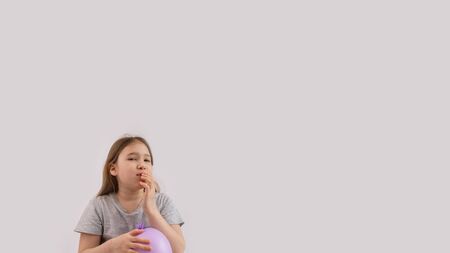 Young sad girl play with protective medical glove. Teenager with glove inflated like balloon. Quarantine, self isolation, depression, social distance, mental health concept. Stock photo.の写真素材