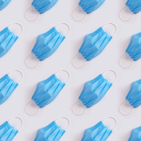 Blue protective medical mask pattern on gray background. Banner of flu coronavirus Covid-19 and quarantine concept. Stock photo.の写真素材
