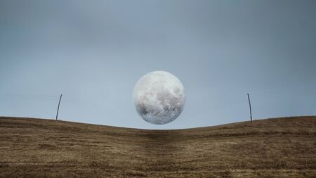 Full moon on electric wires. Banner of nature background with copyspace. Wallpaper pattern. Dark scary park with field, power poles and gray clouds. Landscape misty panorama.の写真素材