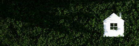 White paper house on a background of green leavesの写真素材