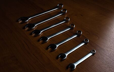 Set of metal wrenches on a wooden background.の写真素材