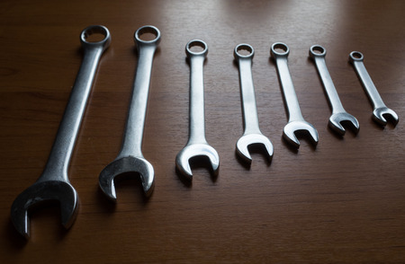 Set of metal wrenches on a wooden background.の写真素材