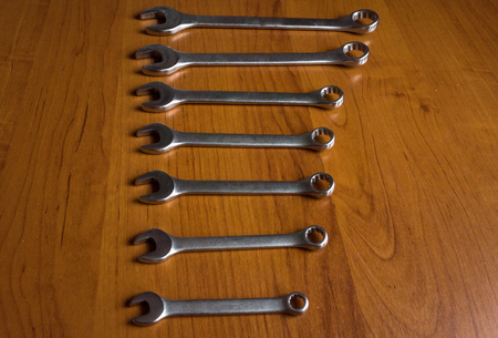 Set of metal wrenches on a wooden background.の写真素材