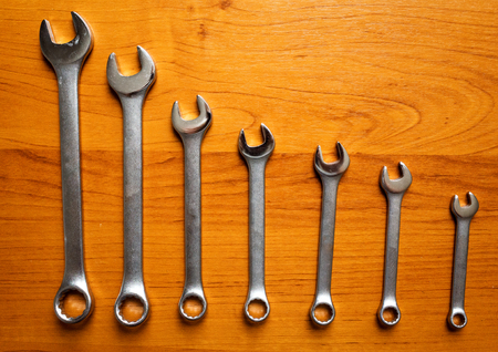 Set of metal wrenches on a wooden background.の写真素材