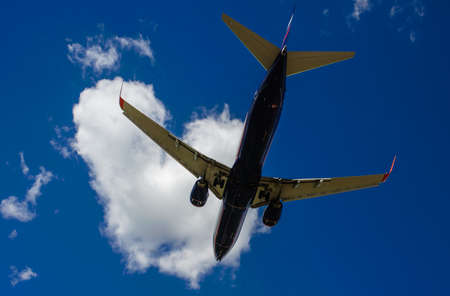 The plane on a background of blue sky and white clouds.