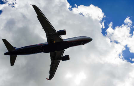 The plane on a background of blue sky and white clouds.