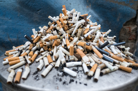 a mountain of cigarette butts in the trashcanの写真素材