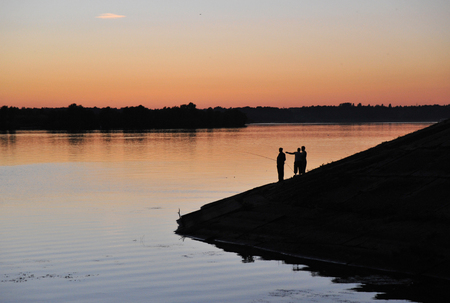 Silhouettes of fishermen on the banks of the Volga River in Uglich.の写真素材
