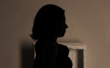 Black silhouette of a girl in a dark roomの写真素材