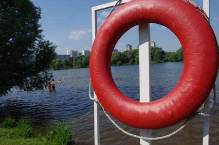 Red lifebuoy on the shore of the lakeの写真素材