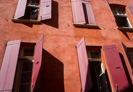 Red shutters on the windows of a house with red walls in the Old Cityの写真素材