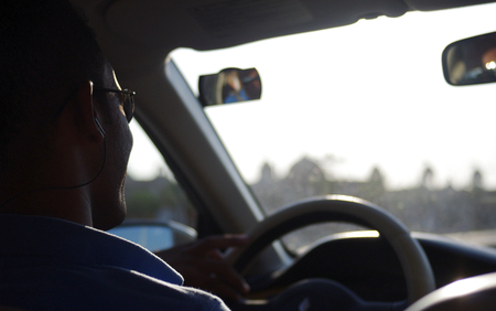 Arab man with sunglasses and headphones at the wheel of a carの写真素材