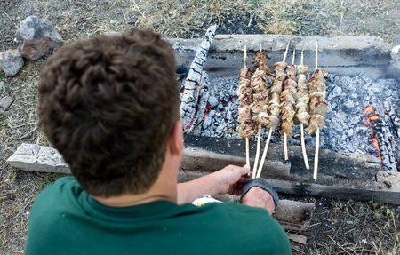 A man grills meat on the coalsの写真素材