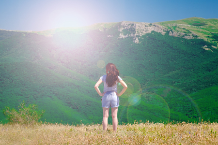 Young girl looking at mountain landscapeの写真素材