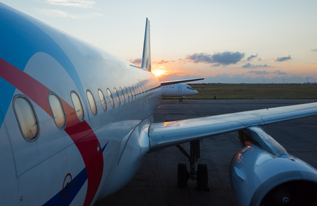 The wing and engine of the plane in the light of the setting sunの写真素材