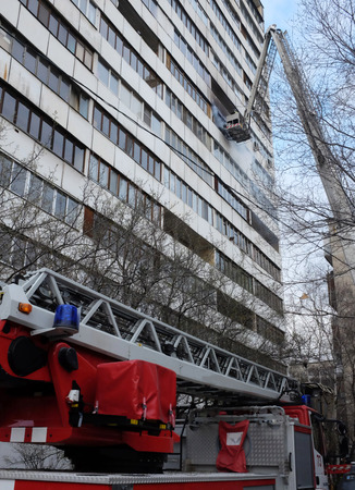 Fire with black smoke in a multistory apartment building.のeditorial素材