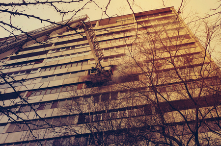 Fire with black smoke in multistory apartment building. Tonedのeditorial素材