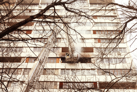 Fire with black smoke in multistory apartment building. Tonedのeditorial素材