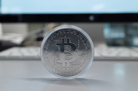 Silver bitcoin on a gray backgroundの写真素材