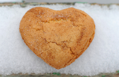 Homemade cookies with sugar and cinnamon in the form of hearts on a background of snowの写真素材