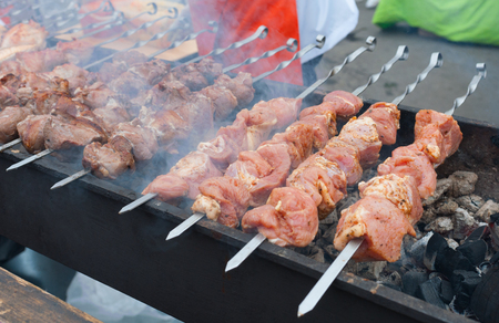 Pieces of meat on skewers are roasted on hot coals.の写真素材