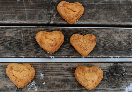 Homemade cookies with sugar and cinnamon in the form of hearts on a wooden backgroundの写真素材