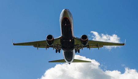The plane on a background of blue sky and white clouds.の写真素材