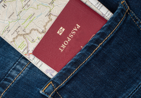A red passport and a map in the pocket of my jeans.の写真素材
