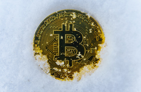 The Gold coin bitcoin against white snow.の写真素材