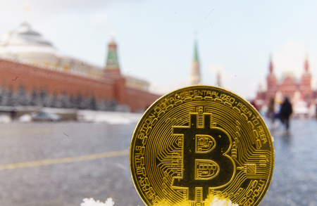 Gold coin bitcoin on the background of the Red Square and the Moscow Kremlin.の写真素材