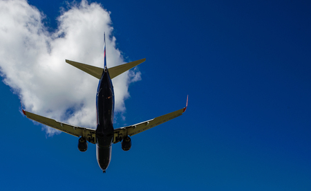 The plane on a background of blue sky and white clouds.の写真素材