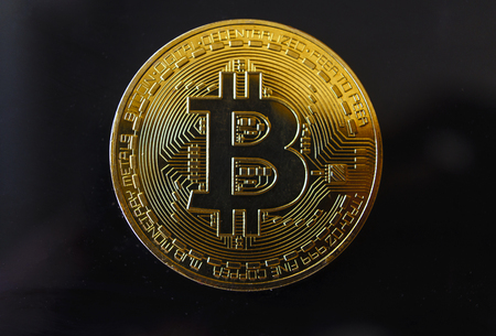 Gold souvenir coin Bitcoin on a black background.の写真素材