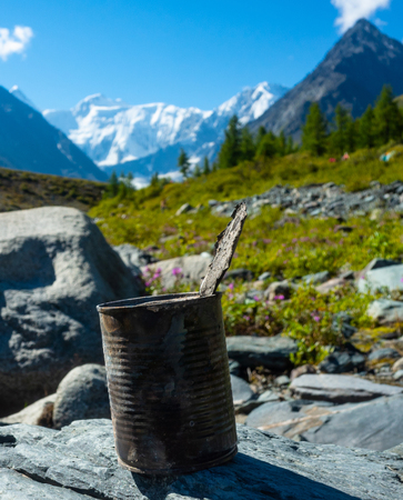 discarded can of canned food on the background of the mountain landscapeの写真素材