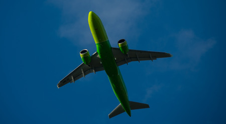 Silhouette of a green plane taking off against a blue skyのeditorial素材