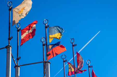 Flags of European countries on flagpoles against the blue sky.