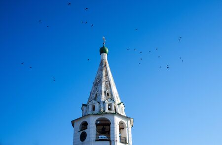 Birds circle the bell tower of the Orthodox ascension Church in Suzdal in winter.の写真素材