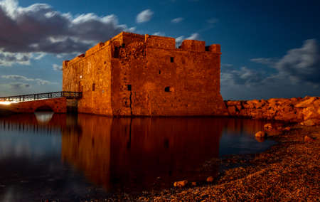 Medieval castle on the shores of the Mediterranean Sea in Paphos city on the island of Cyprus in the light of the full moon.のeditorial素材