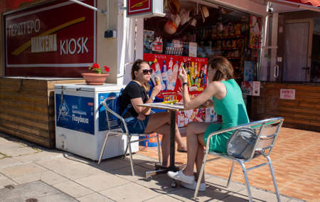 April 20, 2019, Paphos, Cyprus. Two young girls eat ice cream and chat in a summer cafe.のeditorial素材
