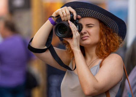 August 18, 2018. Moscow, Russia. A girl in a blue hat takes pictures with Sony's company camera.のeditorial素材