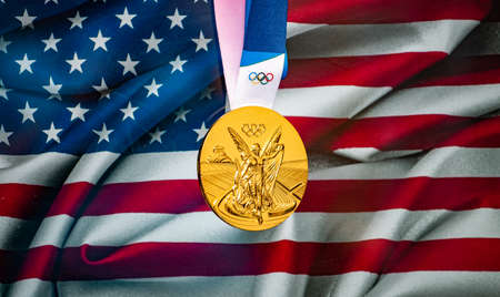 April 22, 2021 Beijing, China. Olympic gold medal against the background of the flag of the United States of Ameria (USA).のeditorial素材