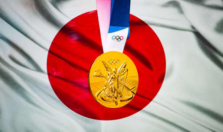 April 22, 2021 Beijing, China. Olympic gold medal against the background of the flag of Japan.のeditorial素材