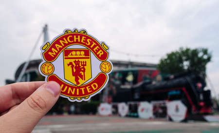 August 30, 2021 Manchester, UK. Manchester United FC football club emblem against the backdrop of a modern stadium.のeditorial素材