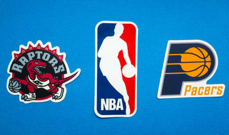 October 1, 2021, Springfield, USA, Emblems of the Toronto Raptors and Indiana Pacers basketball teams on a blue background.のeditorial素材