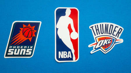 October 1, 2021, Springfield, USA, Emblems of the Phoenix Suns and Oklahoma City Thunder basketball teams on a blue background.のeditorial素材
