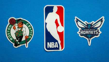 October 1, 2021, Springfield, USA, Emblems of the Boston Celtics and Charlotte Hornets basketball teams on a blue background.のeditorial素材
