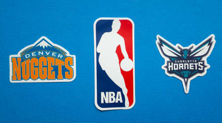 October 1, 2021, Springfield, USA, Emblems of the Denver Nuggets and Charlotte Hornets basketball teams on a blue background.のeditorial素材
